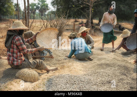 Strada in costruzione in Myanmar.donne su una strada in costruzione equipaggio, setacciatura di ghiaia nei pressi di Bagan Foto Stock