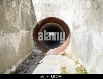 Tunnel per il drenaggio delle acque piovane sotto la strada. Vista attraverso il tubo. Foto Stock