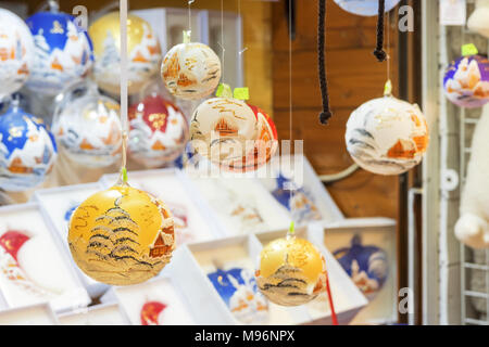 Chiosco di Natale di notte con selezione di decorazioni di albero di Natale. I faretti del chiosco creano riflessi luminosi sui bordi dell'oro Foto Stock