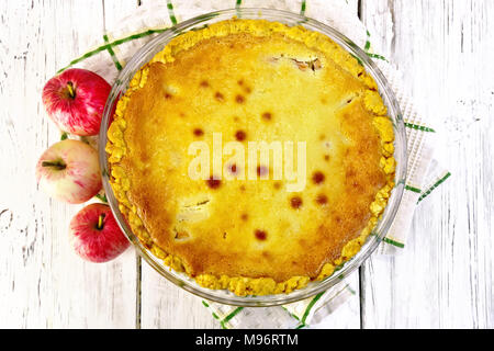 Torta di mele con panna acida salsa su un asciugamano, frutto su un asse di legno sfondo Foto Stock