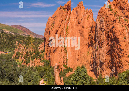 Vista di bizzarre formazioni rocciose nel Giardino degli dèi park, Colorado Springs, Colorado; sul fondo, piccole figure di persone che camminano sul terreno Foto Stock