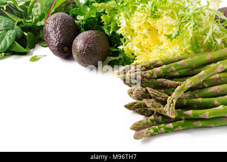 Erbe verdi, asparagi e avocado nero su uno sfondo bianco. Vista dall'alto. Lay piatto Foto Stock