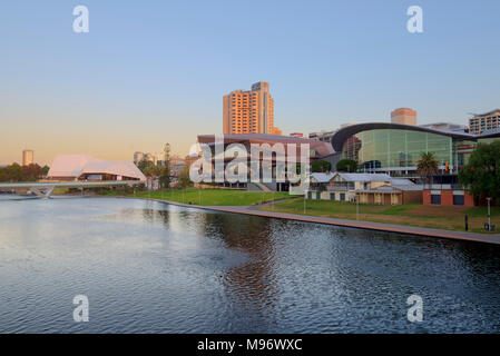 La skyline di Adelaide si accende al crepuscolo attraverso la serena River Torrens. Foto Stock