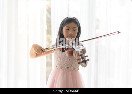 Ragazza carina suona il violino finestra vicino a casa Foto Stock