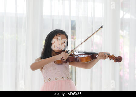 Ragazza carina suona il violino finestra vicino a casa Foto Stock