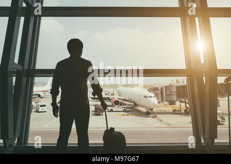 Lato posteriore del ragazzo del viaggiatore in termainal all aeroporto guardando il piano di volo sopra aeroporto, viaggi e vacanze di concetto di stile di vita Foto Stock