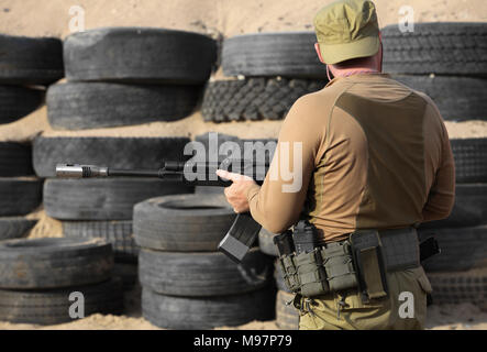 Sparatutto con un kalashnikov fucile da assalto vicino alla vista posteriore Foto Stock