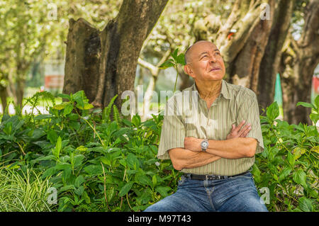 Veduta esterna del vecchio uomo si siede su un banco di lavoro, godendo la natura e avente un buon riposo. Tutti i problemi lasciati dietro Foto Stock