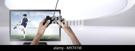 Mani che tengono il controller di gioco con il giocatore di calcio in televisione Foto Stock