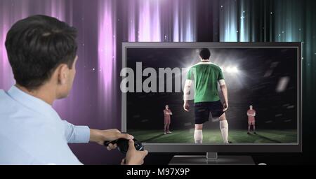 Mani che tengono il controller di gioco con il giocatore di calcio in televisione Foto Stock