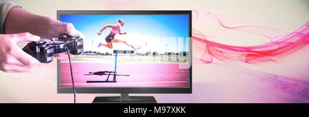 Mani che tengono il controller di gioco con ostacolo ponticello dello sport in televisione Foto Stock