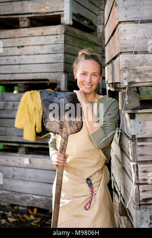 Ritratto di donna sorridente in piedi in scatole di legno Foto Stock