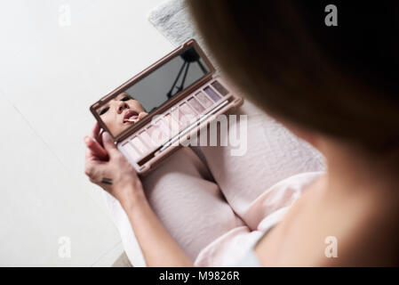 Donna con specchio a mano il rossetto Foto Stock