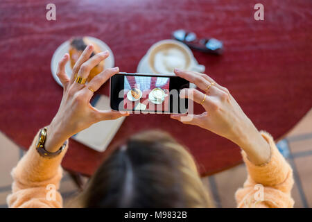 Overhead view of woman in a cafe taking cell phone picture Foto Stock