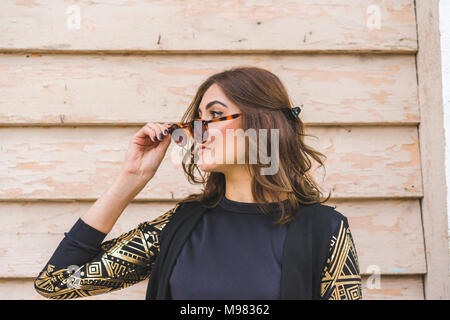 Giovane donna con occhiali da sole guardare qualcosa Foto Stock