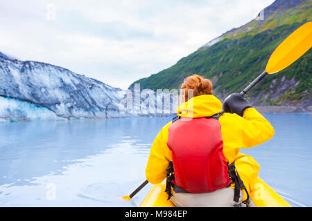 Stati Uniti d'America, Alaska, Valdez, giovane donna in kayak di fronte del ghiacciaio Valdez Foto Stock