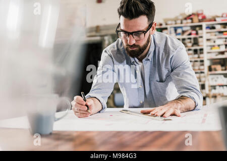 Uomo al lavoro su piano di costruzione Foto Stock