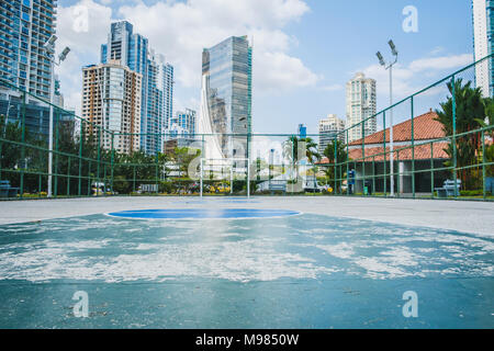 Campo da basket in Panama City - Campo sportivo nel parco all'aperto con lo skyline della città Foto Stock