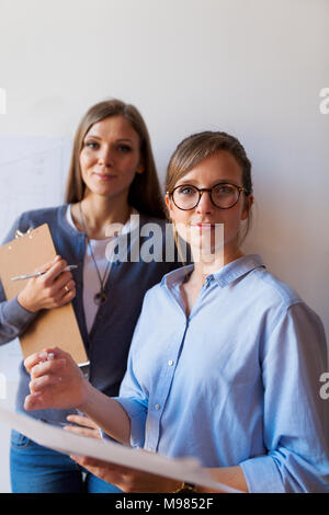 Femmina di architetti che lavorano su un progetto, guardando fiduciosi Foto Stock