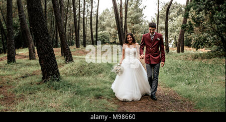 Felice sposa e lo sposo passeggiate in foresta Foto Stock