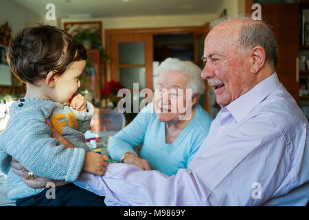 Grande-nonni giocare con la bambina a casa Foto Stock