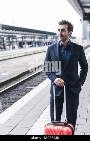 Giovane imprenditore in attesa in banchina della stazione Foto Stock