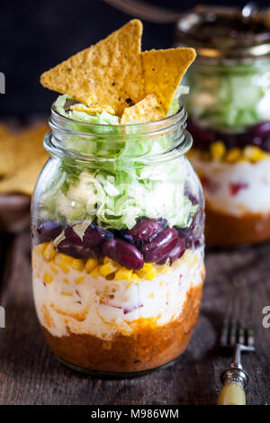 Taco salad, chili con carne, panna acida, mais, fagioli rossi, di lattuga iceberg in un vaso, nacho chips Foto Stock