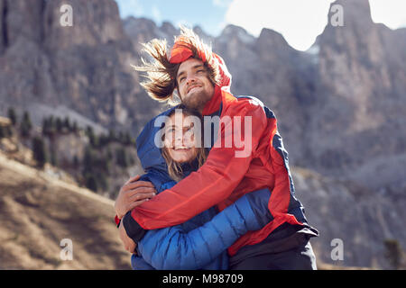 Felice coppia giovane costeggiata nelle montagne di vento Foto Stock