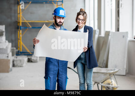 Builder con imprenditrice nel luogo di costruzione Foto Stock