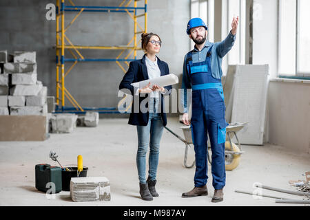 Builder con imprenditrice nel luogo di costruzione Foto Stock