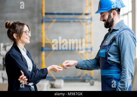 Donna cryptocurrency dando ad un builder Foto Stock