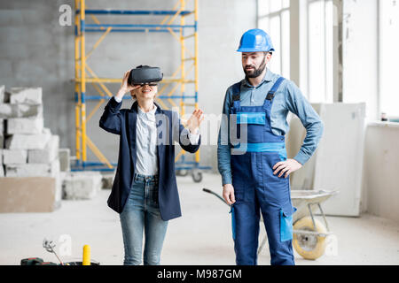 Client di donna che indossa gli occhiali VR al sito in costruzione Foto Stock