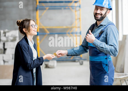 Donna cryptocurrency dando ad un builder Foto Stock