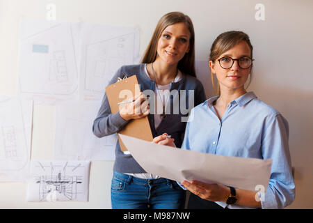 Femmina di architetti che lavorano su un progetto, guardando fiduciosi Foto Stock