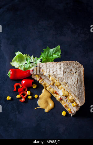 Sandwich di Pollo con mais, salsiccia per pizza e salsa al curry sulla terra scura Foto Stock