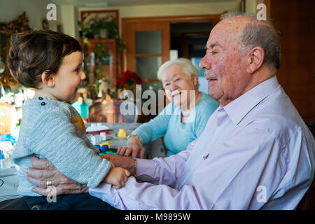 Grande-nonni giocare con la bambina a casa Foto Stock
