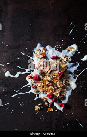 Muesli frutta essiccata con lamponi e fragole e mirtilli rossi di yogurt splash Foto Stock