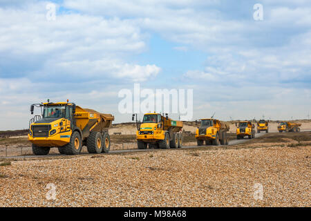 Convoglio di autocarri con cassone ribaltabile articolati che trasportano shingle aggregato. Foto Stock