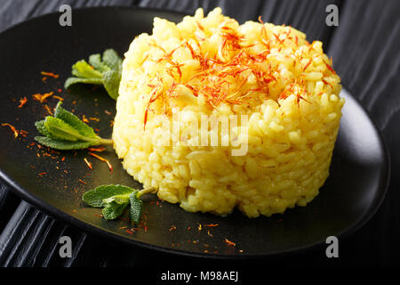 Risotto di riso carnaroli con zafferano e menta closeup su una piastra. vista orizzontale Foto Stock