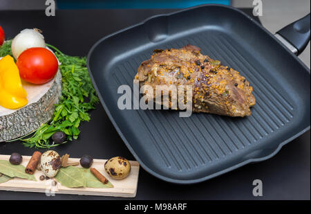 Preparati a base di carne marinata su una padella per grigliare accanto alle verdure, pepe, cipolle, aglio, pomodori, aneto, prezzemolo e uova di quaglia su una tavola di legno su un livello di grigio Foto Stock