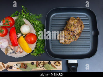 Angolo di alta vista di preparati a base di carne marinata su una padella per grigliare accanto alle verdure, pepe, cipolle, aglio, pomodori, aneto, prezzemolo e uova di quaglia su un legno Foto Stock