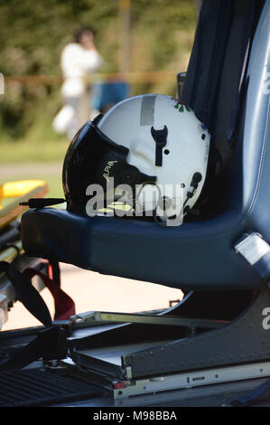 Vista ravvicinata di un pilota del casco sul sedile nella cabina di pilotaggio di un elicottero del Galles Air Ambulance Service Foto Stock