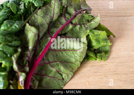 Red Rainbow Chard sulla luce di un contatore di legno Foto Stock