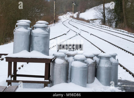 Coperta di neve bidoni per il latte sulla piattaforma a Hampton Loade stazione, Severn Valley Railway vicino a Bridgnorth, Shropshire, Regno Unito Foto Stock