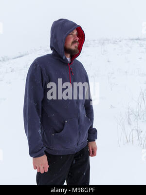 Uomo che indossa vuoto felpa con cappuccio grigia, in background urbano vicino al fiume. Foto Stock