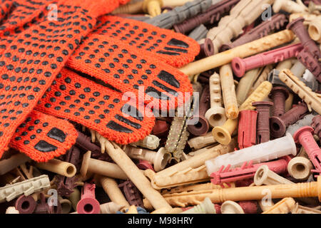 Guanti di protezione arancione giacente sullo sfondo delle spine. Close-up Foto Stock