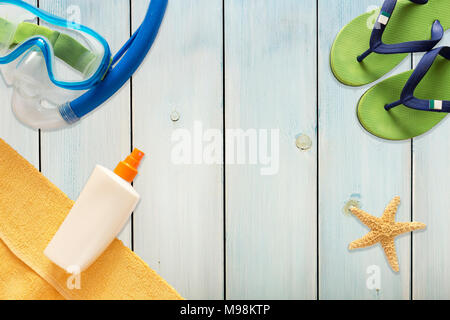 Mare pantofole, scuba mask e starfish sulla luce blu sullo sfondo di legno Foto Stock