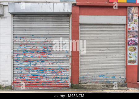 Martoriato di rullo di chiusura sportello con vernice scrostata off. Metafora recessione, high street chiusure, vacante negozi. Ostruito o ostruzione del concetto. Foto Stock