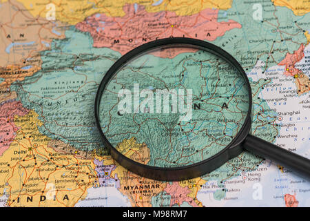 Mappa della Cina attraverso la lente di ingrandimento su una mappa del mondo Foto Stock
