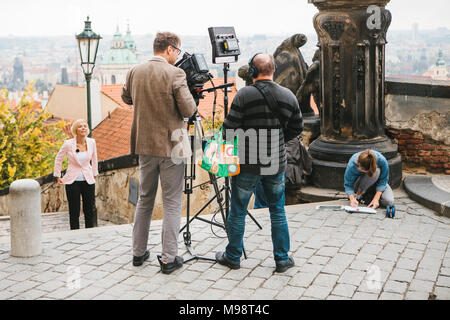 Team di operatori e giornalisti sparare relazione accanto al Castello di Praga Foto Stock